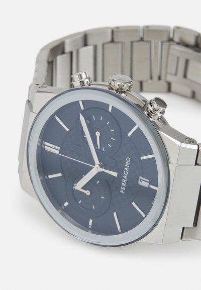 Silver stainless steel watch with a dark blue textured dial, three sub-dials, and silver accents. Features a link bracelet and crown.