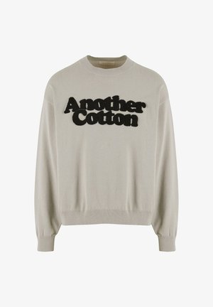 Helehallidest puuvillane sviiter, ümar kaelus, soonikud mansettides ja allservas. Ees on must tõstetud tekst "Another Cotton".