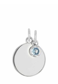 Srebrny okrągły wisiorek z małym niebieskim kamieniem zawieszonym na kółku, na białym tle.