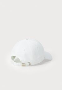 Pălărie din bumbac alb, cu bor flexibil, curea ajustabilă la spate cu elemente metalice și șase orificii de ventilație pe crown.