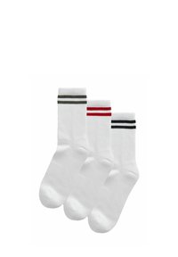 Drie paren witte crew-sokken, met ribbelstructuur en gekleurde strepen in groen, rood en zwart bij de boord.