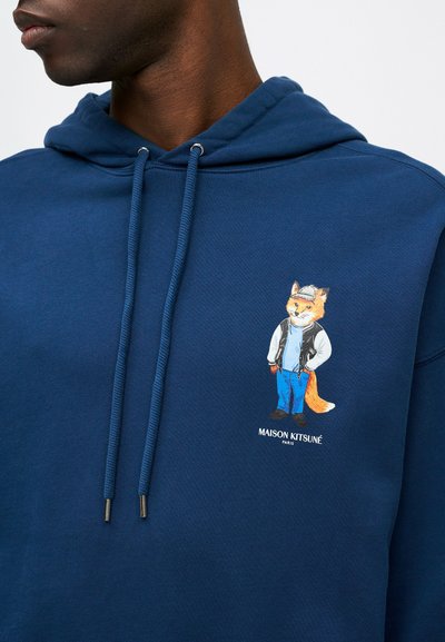 Sudadera de algodón azul marino con un gráfico de un zorro con gorra, chaqueta de mezclilla y pantalones azules; incluye capucha con cordón y puntas de metal.