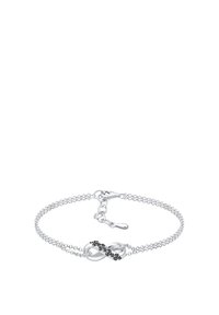Silverfärgad kedjearmband med en oändlighetssymbol prydd med svarta stenar, säkrad med en krabbklämma och justerbar kedja för storleken.