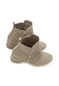 Bottes de cheville beiges en daim avec un motif découpé texturé, dotées d'un petit talon carré et d'une fermeture éclair sur le côté pour un enfilage facile.