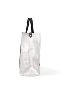 Borsa tote metallica argento con design piatto, manici in pelle nera e un accento a forma di bottone circolare dorato nella parte superiore. Dettaglio della superficie testurizzata.
