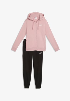 Różowa bluza z kapturem na zamek z troczkami, zestawiona z czarnymi spodnimi dresowymi, oba z białymi logo Puma na klatce piersiowej i udzie.