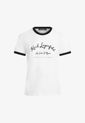 Wit T-shirt met korte mouwen, zwarte kraag en mouwranden, met de tekst "Karl Lagerfeld La Côte D' Azur French Riviera" aan de voorkant.