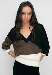 Kootud sviiter V-kaelusega, mustris värve must, pruun ja kreem. Tekstuuriga lõngad ning pehme valge alläär.