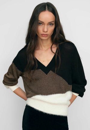 Pletený sveter s výstrihom do V, s dizajnom v blokoch farieb v čiernej, hnedej a krémovej. Textúrované priadze s chlpovým bielym spodným lemom.