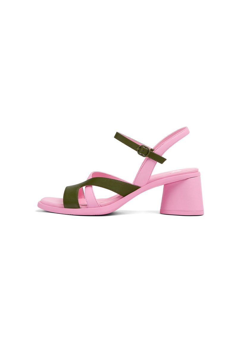 Pink heeled sandal with green cross straps and an adjustable green ankle buckle strap, showing side profile on a white background.