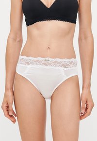 Hvite bomullstruser med blomster-lace liv og små dekorative detaljer, med en glatt tekstur og fullt dekning design.