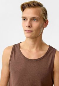 Bruine katoenen tanktop met een ronde halslijn, zonder mouwen en een gladde textuur. Heeft een getailleerde pasvorm en minimale stikseldetails.