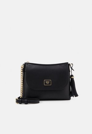 Czarna skórzana torba crossbody z złotym łańcuszkowym paskiem, detalem z chwostem i plakietką z logo DKNY na przednim klapie.