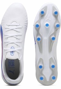 Scarpe sportive bianche con un design elegante, caratterizzate da una tomaia liscia, lacci nascosti, dettagli blu e una suola testurizzata con borchie blu.