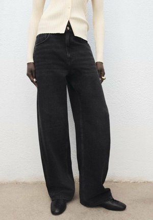 Black wide-leg denim jeans with a high waist, five-pocket design, and subtle fading. Paired with a cream ribbed cardigan.