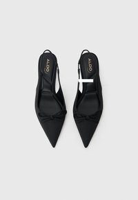 Tacchi slingback neri a punta con un'applicazione a fiocco, tomaia in tessuto morbido e soletta nera imbottita. Logo ALDO in oro sulla soletta.
