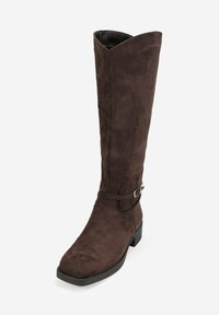 Bota de ante marrón hasta la rodilla con punta cuadrada, un detalle de correa y hebilla minimalista, y un tacón cuadrado bajo. Textura suave.
