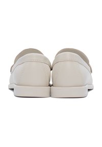 Scarpe slip-on in pelle beige con una finitura liscia, un design a profilo basso e cuciture in contrasto lungo il bordo superiore. Suole piatte in gomma.