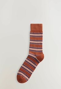 Chaussettes marron avec des rayures horizontales blanches, bleues et rouges. Poignet côtelé. Matière en mélange de coton avec une texture douce. Longueur standard.