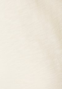 Weiches, cremefarbenes Gewebe mit glatter Textur, das ein dezentes meliertes Muster aufweist. Die Oberfläche ist gleichmäßig und leicht.