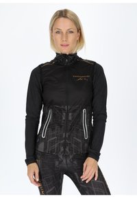 Schwarze ärmellose Jacke mit hohem Kragen, ausgestattet mit einem geometrischen Muster, einem Frontreißverschluss und grauen Akzenten. Logo auf der Brust angebracht.