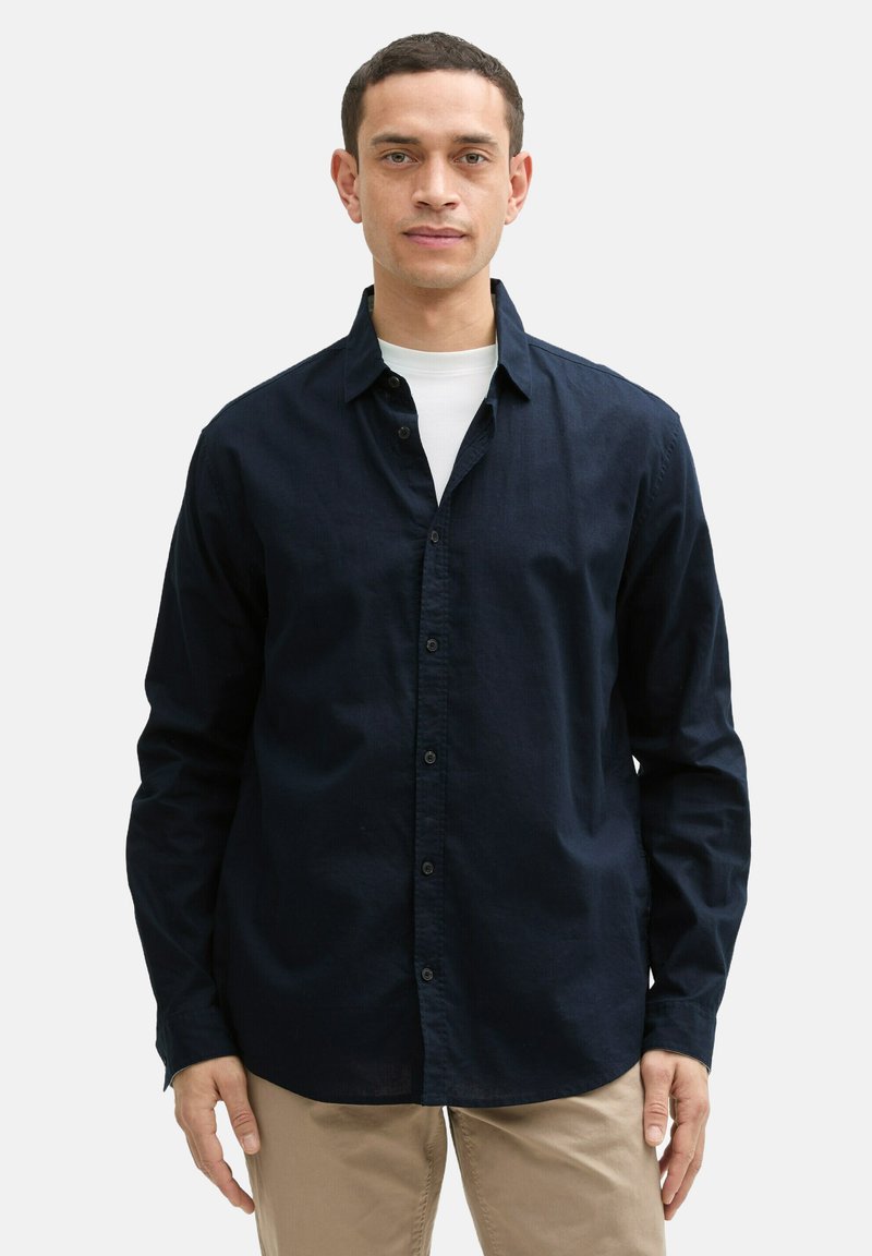 Marineblauw overhemd met knopen en een klassieke kraag, lange mouwen en een soepele textuur. Gemaakt van lichtgewicht stof met een casual pasvorm.