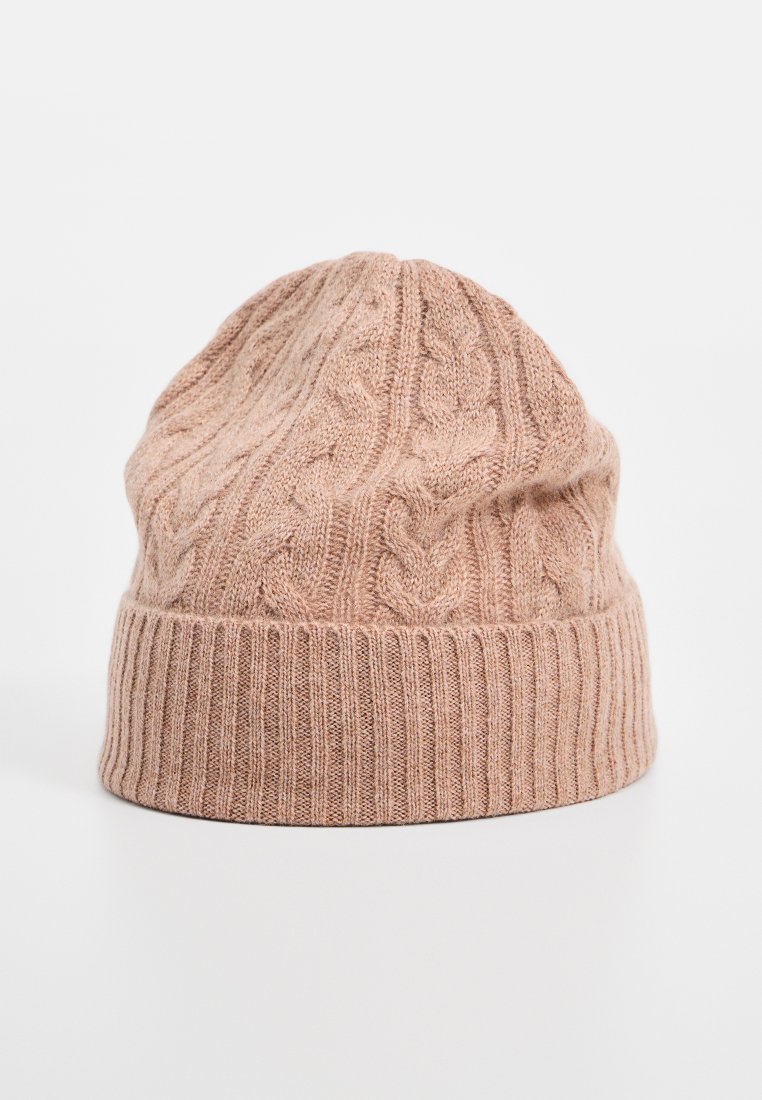 Beżowa dziana czapka z wzorem w warkocze i podwiniętym ściągaczem, prezentowana na neutralnym tle.