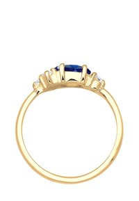 Złoty pierścionek z centralnym owalnym niebieskim kamieniem, otoczonym mniejszymi przezroczystymi kamieniami, z gładką, wypolerowaną obrączką i podniesionymi rzędami szpilek.