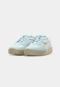 Adidași din suede albastru deschis cu accente bej, design cu șireturi, textură netedă și talpă din cauciuc. Caracterizată printr-un logo proeminent pe latură.