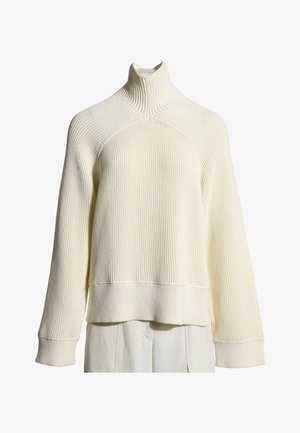 Pull en maille côtelée de couleur crème avec col montant, manches longues et larges poignets présenté sur fond blanc.