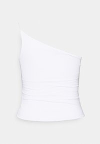 Top blanc asymétrique sans manches avec une coupe près du corps et un tissu lisse, présenté sur un fond gris clair.
