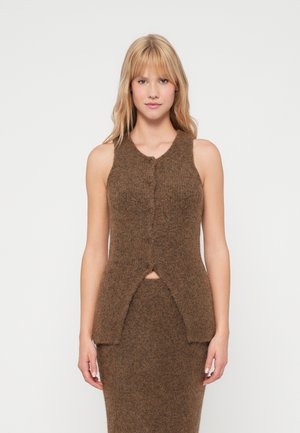 Pull sans manches en laine marron avec un col rond, des boutons à l'avant et des fentes à l'ourlet. La texture est douce et chaude.