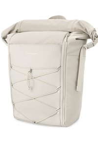 Sac à dos à rabat en tissu beige clair avec détail en cordon élastique, fermeture éclair et poignée latérale. Texture lisse avec un branding minimal.
