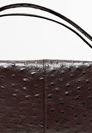 Bruine leren handtas met een gestructureerde afwerking, voorzien van verhoogde stippen, een rechthoekige vorm en twee slanke handgrepen om te dragen.