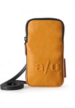 Lederhandytasche in senfgelb mit strukturiertem Außenmaterial, schwarzem Reißverschluss und verstellbarem schwarzen Tragegurt. Mit eingraviertem "a/u"-Logo.