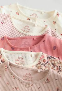 Fyra babytopparna ordnas överlappande. Materialen är bomull i pastellfärger: blommönster, rutor och texturerade mönster med rundad halsringning och knappstängning.