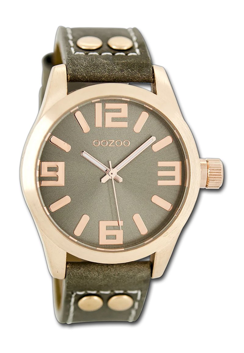 Montre avec bracelet en cuir vert et boîtier en or rose, affichage rond, grands chiffres arabes et aiguilles argentées. Deux accents métalliques sur le bracelet.