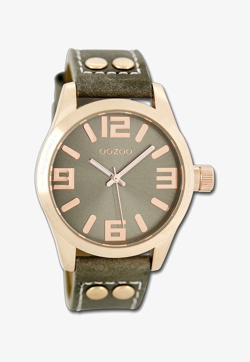 Montre avec bracelet en cuir vert et boîtier en or rose, affichage rond, grands chiffres arabes et aiguilles argentées. Deux accents métalliques sur le bracelet.