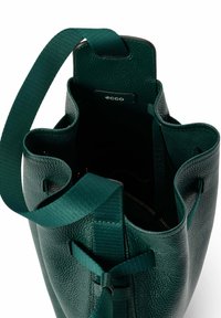 Borsa a secchiello verde in pelle con finitura testurizzata, tracolla in tessuto e chiusura con coulisse. Presenta una tasca interna con cerniera.