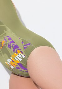 Olivově zelené jednodílné plavky s vícebarevným grafickým designem a fialovým, oranžovým a bílým textem. Hladká, pružná tkanina.