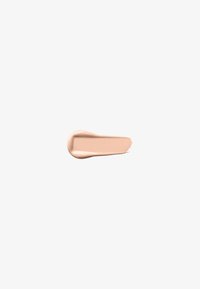 Lys beige kremflekk med en jevn tekstur, litt buet form og en blank finish, mot en helt hvit bakgrunn.