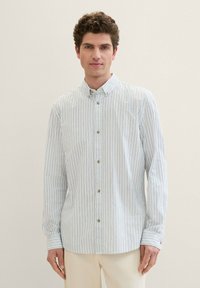 Camisa de botones a rayas en azul claro y blanco, con cuello, mangas largas y botones marrones. Tejido suave con un corte holgado.