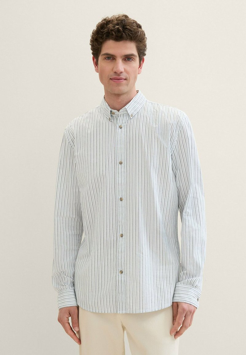 Camisa de botones a rayas en azul claro y blanco, con cuello, mangas largas y botones marrones. Tejido suave con un corte holgado.