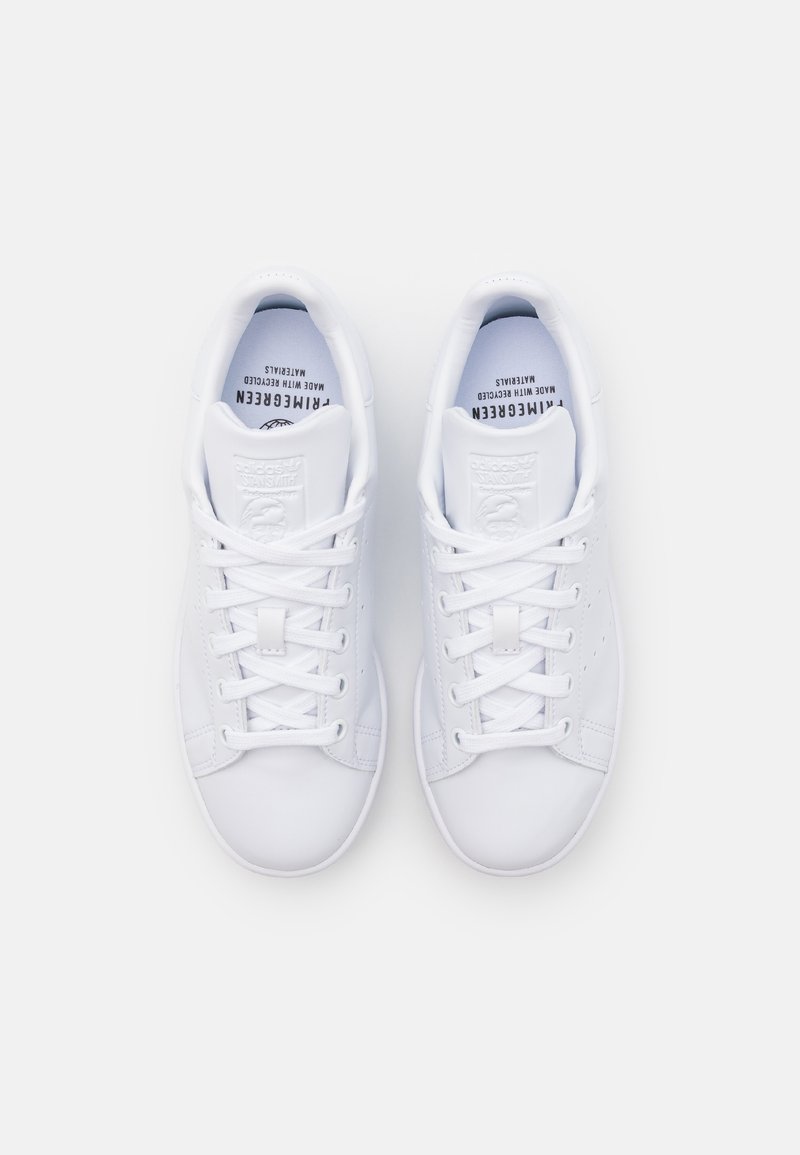 Baskets blanches avec une finition en cuir lisse, bout rond, design lacé, languette et col rembourrés, avec un logo sur la semelle intérieure.