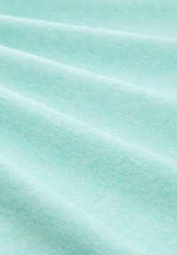 Lichtblauwe stof met een gladde textuur, met duidelijke plooien en een subtiel gemêleerd patroon. Zacht materiaal, gelijkmatig geweven.