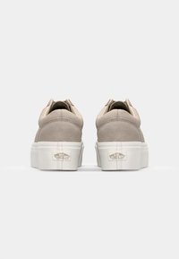 Beige semskede sneakers med lav skæring, hvid gummisål og signaturlogo på hælen. Har syningdetaljer og runde snørebånd.