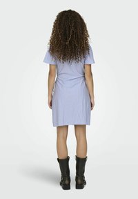 Korte, aansluitende jurk van lichtblauwe stof met verticale witte strepen; korte mouwen en een splitzoom, gecombineerd met kniehoge zwarte laarzen.