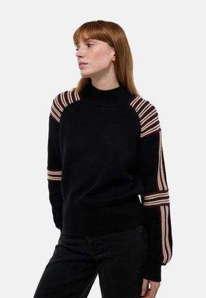 Pull en tricot noir avec un col haut, présentant des accents rayés multicolores sur les épaules et les manches. Texture douce avec des poignets côtelés.