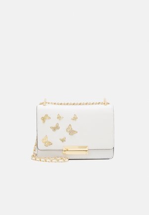 Bolso bandolera blanco con adornos dorados en forma de mariposa y una correa de cadena dorada sobre un fondo liso.