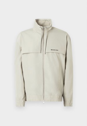 Light grey windbreaker jacket with a high collar, front zip closure, elastic cuffs, and relaxed fit; features a subtle logo on the chest.